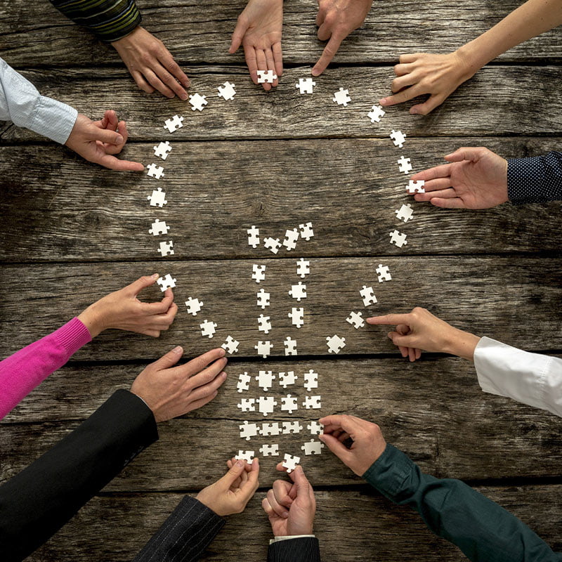 A diverse group of individuals holding hands in a circle, symbolizing the power of collaboration.